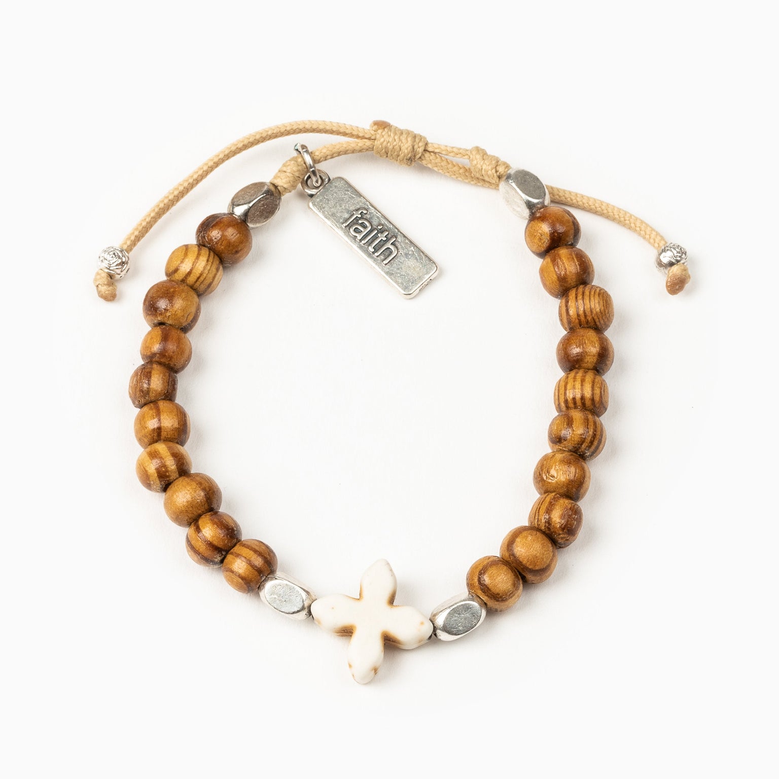 Grounded in Faith Olive Bead Bracelet with small white cross and faith charm tag on tan cording